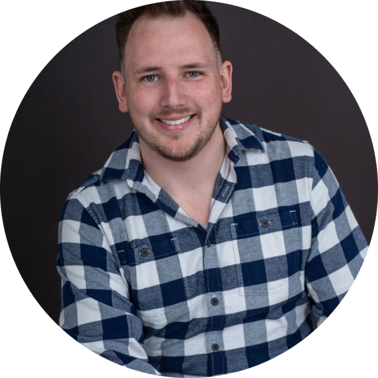 Smiling male therapist in plaid shirt for mental health counseling.