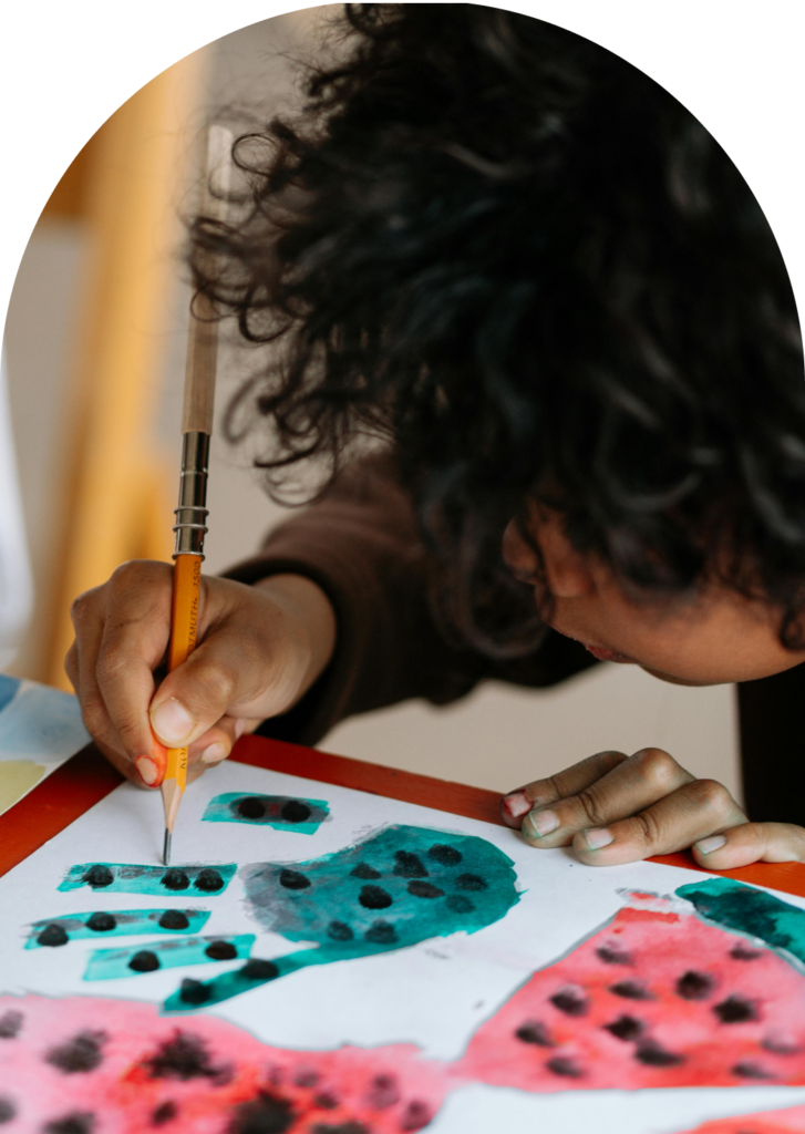 Child painting with watercolors, promoting mental health and wellness.